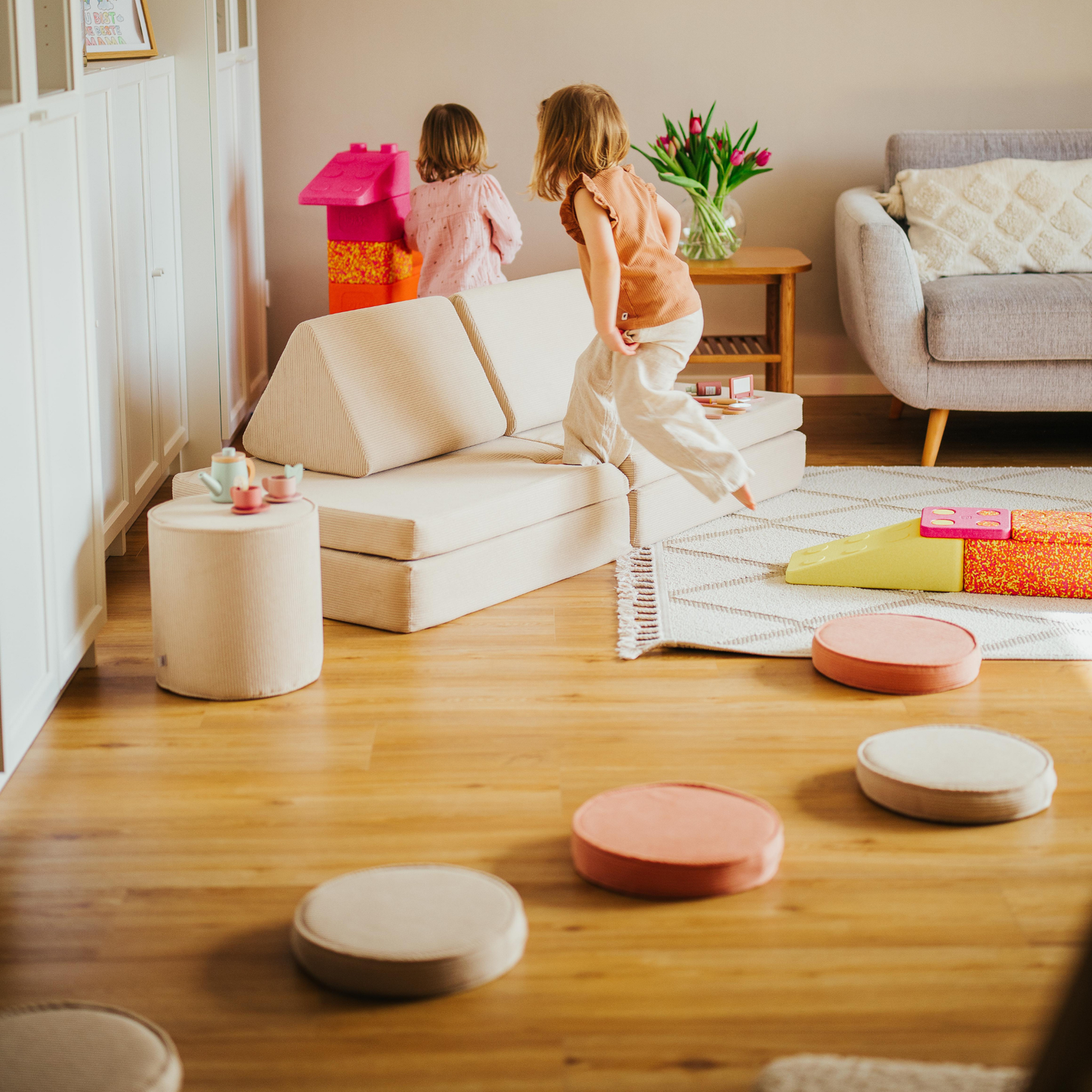 Kleinkind springt auf malwim Spielsofa Cord Beige – Bewegungsfreude zu Hause
